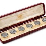 An Edwardian cased set of six 'Renault' sterling silver blazer buttons by Alfred Wigley of Birmingham, 1902