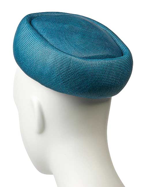 A SQUARE PILLBOX HAT OF TEAL STRAW AND A HAT STAND