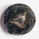 Silver stud button, with a domed face decorated with applied granules, very worn and flattened, and rings of twisted wire.