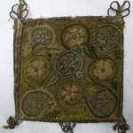 A flat, square bag of linen worked in tect stitch with silver thread ground and coloured silk scrolls, flowers and leaves.