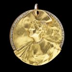 Locket/ pendant of gold set with diamonds. The front of the locket features the head and shoulders of a woman. Within is a mirror.